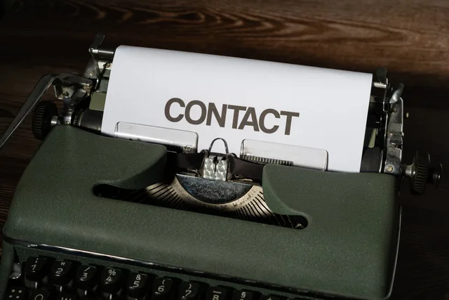 Close-up of a vintage typewriter with a white paper sheet displaying the word 'CONTACT' in bold text. Comparing contact-based, seat-based and usage-based pricing