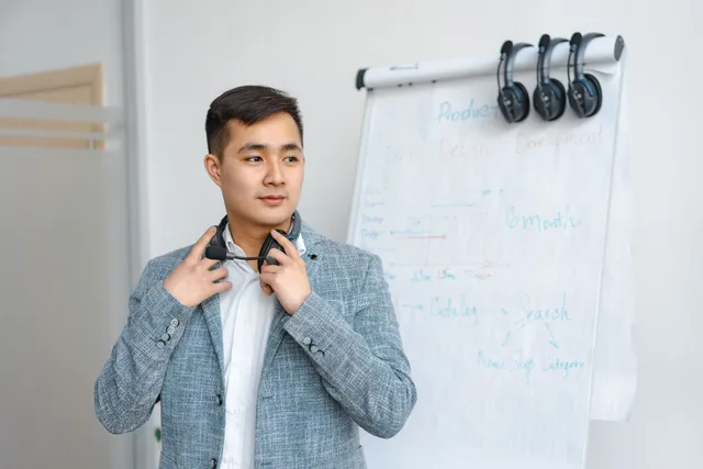Confident office worker standing by whiteboard with development timeline. Ideal for business themes. Evaluating capacity planning for a marketing department